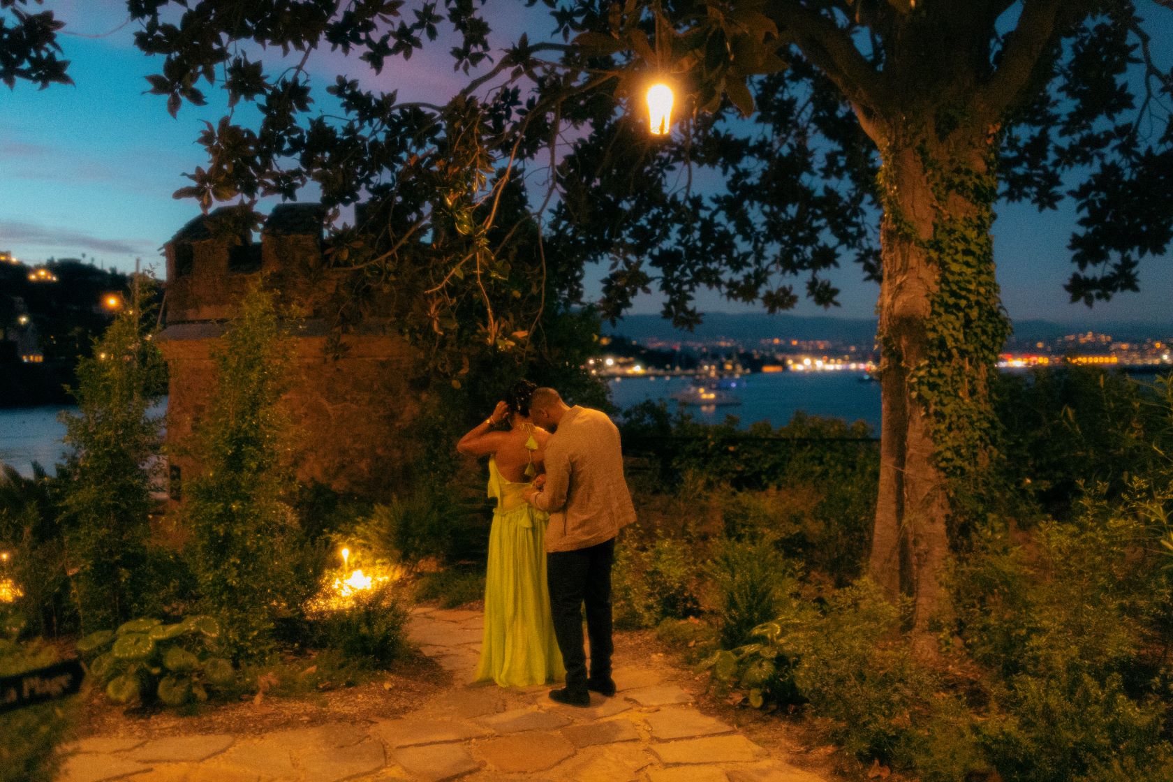 Couple de dos le soir, l'homme arrange la robe de la femme